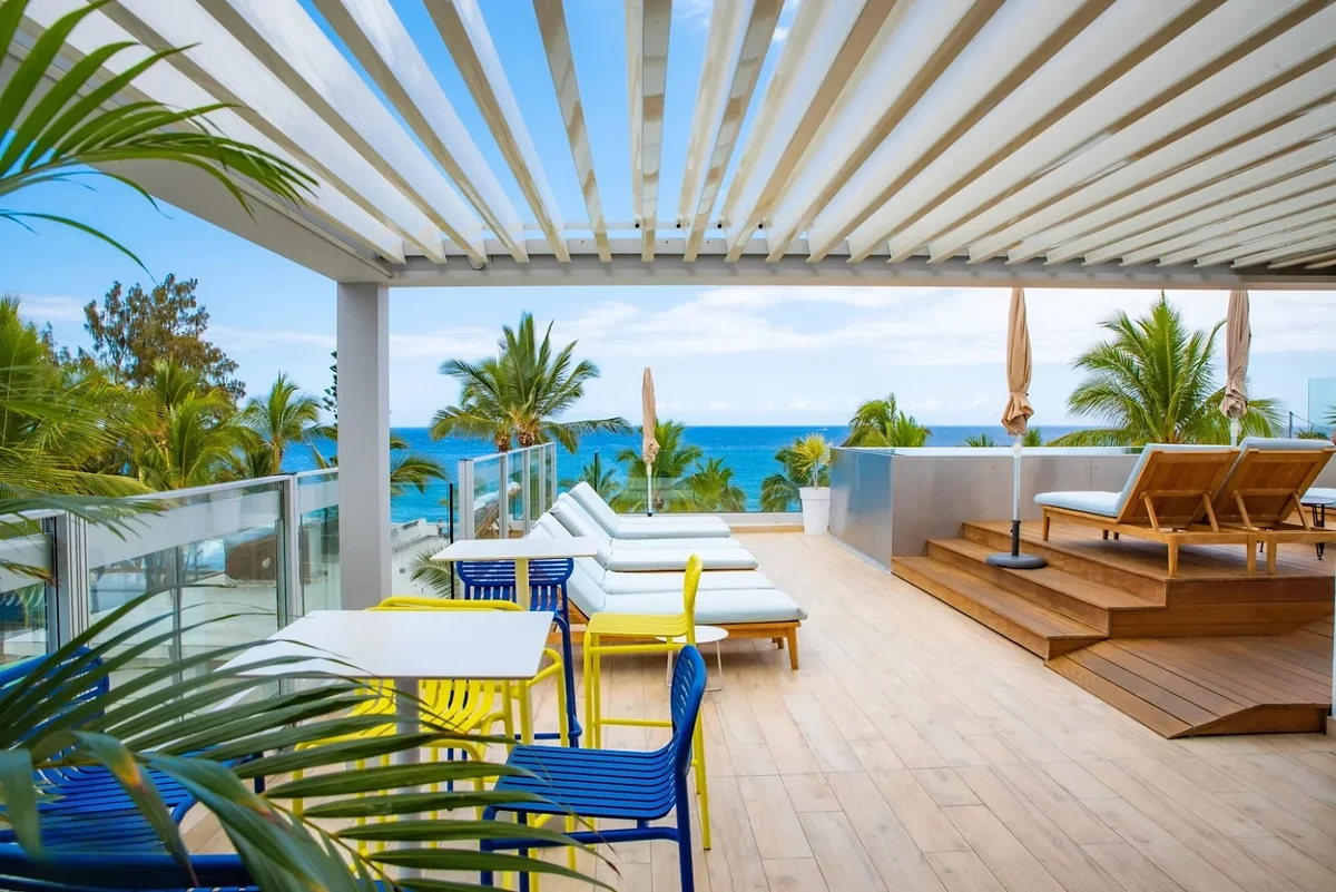 Le rooftop sous sa pergola, ses transats et la vue sur l'océan